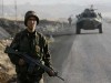 Turkish army soldier picture. Turkish soldiers, followed by an armoured personnel carrier (APC), patrol a road surrounded by rugged mountains in the south-eastern Turkish province of Sirnak, bordering Iraq, November 8, 2007.